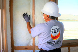 A BDI insulation contractor installing batt insulation